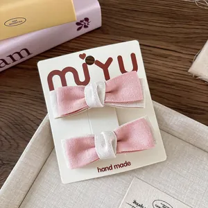 Dettaglio di fermagli per capelli con fiocchi in tessuto rosa e beige fatti a mano