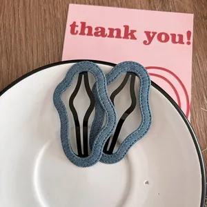 Détails de barrettes à cheveux en denim bleu avec bords ondulés sur plat en céramique