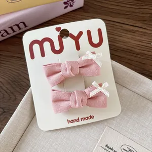 Dettaglio di fermagli per capelli a fiocco in cotone rosa con pizzo bianco su carta