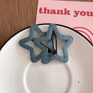 Détail de barrettes à cheveux en denim en forme d'étoile sur une assiette en céramique