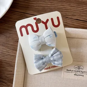 Close-up of handmade floral and plaid fabric bow hair clips for girls on display card