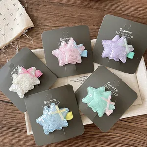 Détail de cinq barrettes étoiles à paillettes colorées avec nœuds sur cartes