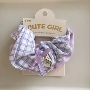 Detail of lavender plaid scrunchie with ribbon bow and button on card display