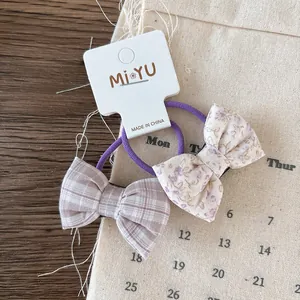 Detail of floral and plaid bow hair ties on a display card for girls' hair styling