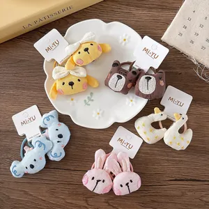 Detailed view of cute embroidered plush animal hair ties with soft linen texture