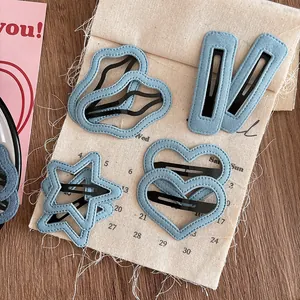 Détail de barrettes à cheveux en denim bleu clair en formes de cœur et d'étoile