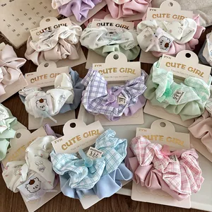 Close-up of assorted plaid and floral fabric scrunchies with cute handmade bow details