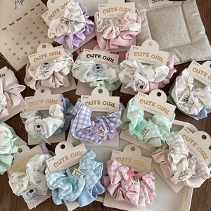 Detailed view of assorted plaid and floral fabric scrunchies on a cute display card