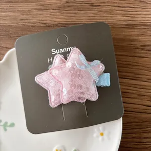 Détail d'une pince à cheveux étoile à paillettes roses avec nœud en maille