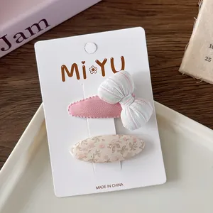 Detail of sweet pink floral and striped bow hair clips set on a display card