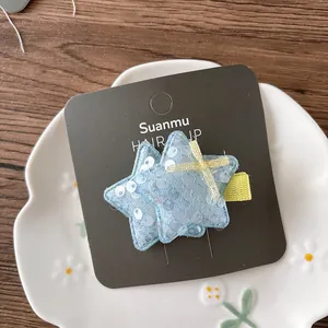 Gros plan sur une pince à cheveux étoile à paillettes avec petit nœud jaune