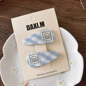 Blue plaid hair clips with cute plush puppy patch and embroidered text on card
