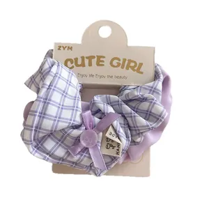 Purple plaid fabric scrunchie with lavender ribbon bow and button on card