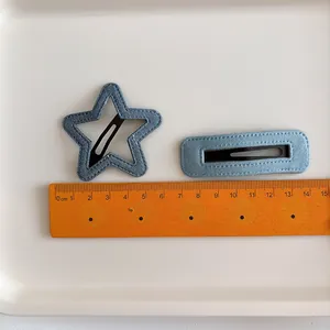 Lot de barrettes en denim bleu clair en forme d'étoile et rectangle sur plateau blanc