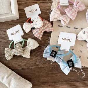 Floral and plaid bow elastic hair ties set for girls on a warm wooden background