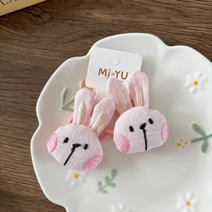 Close-up of pink 3D stuffed bunny hair ties with detailed embroidery on a display card