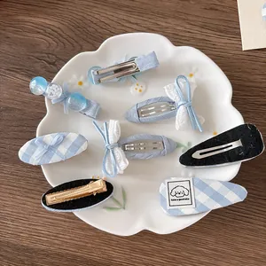 7-piece blue plaid bow hair clip set with cute patterns in a decorative white dish