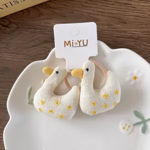 Close-up of cute cartoon stuffed duck hair ties with embroidery on a ceramic tray