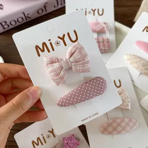 Detail of pink floral bow hair clip and polka dot snap clip on display card