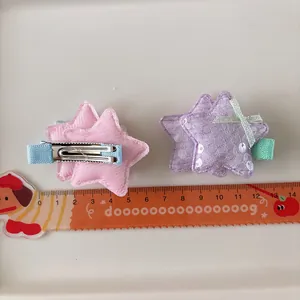 Détail de pinces à cheveux étoiles à paillettes avec nœuds et clips crocodiles en métal