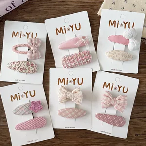 Detail of pink floral fabric hair clips set with bows and stars on display cards