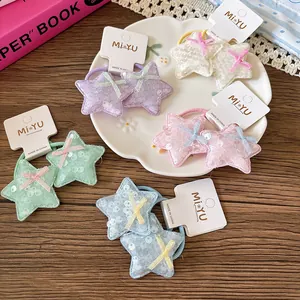 Détail de cinq paires d'élastiques étoiles à paillettes avec nœuds sur cartes blanches