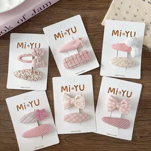 Close-up of pink floral and checkered bow hair clips set on MiYU display cards