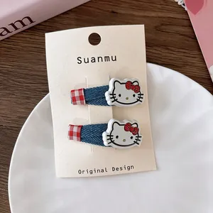Detail of Hello Kitty hair clips set with denim fabric and red plaid patterns