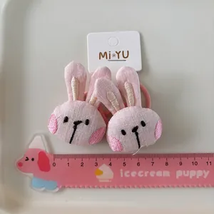 Detail of pink embroidered plush bunny hair ties for girls with measurement scale
