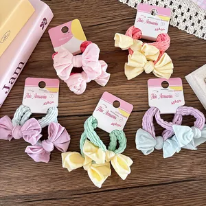 Détail des chouchous nœuds colorés aux tons macarons sur des cartes de présentation
