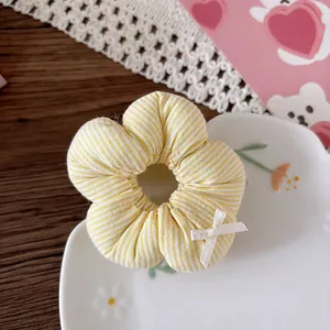 Dettaglio di un elastico floreale con strisce gialle e un fiocco su un piatto ceramico