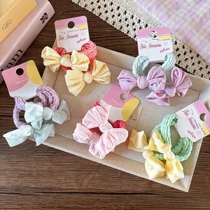 Détail des chouchous colorés avec nœuds aux tons macarons sur carte de présentation
