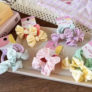 Détail de chouchous à nœuds pastel en tissu plissé sur des cartes de présentation
