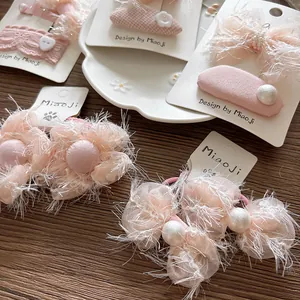 Detail of pink chiffon bow hairpins and elastic ties with pearls and lace on tray