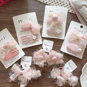Pink ribbon bow and floral hair clips set with pearls on white display card