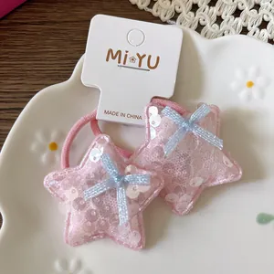 Détail de chouchous étoiles à paillettes roses avec nœuds en résille sur carte support