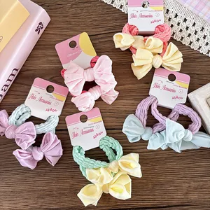 Détail de chouchous à nœuds en tissu coloré aux tons macarons sur cartes de support