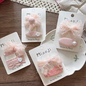 Detail of pink chiffon bow hair clips and lace floral hair ties on a display card