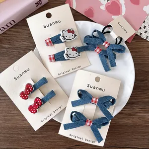 Detail of red bowknot and denim hair clips with cute kitty resin motifs for girls