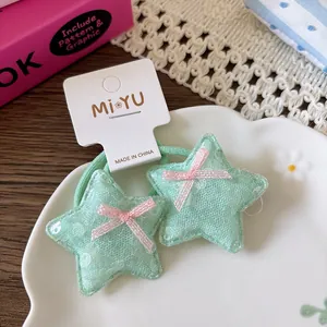 Détail d'élastiques cheveux en dentelle vert menthe avec nœuds roses pour filles