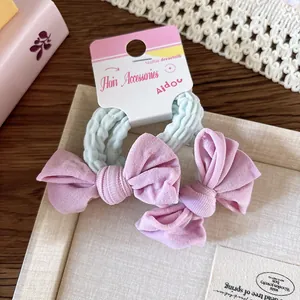 Détail d'élastiques à cheveux haute élasticité avec grands nœuds roses sur emballage