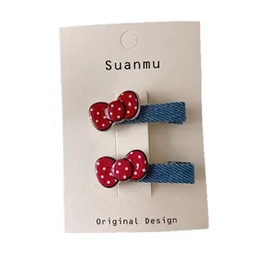 Cute red polka dot bow and denim hair clips for girls displayed on a card