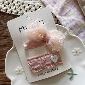 Detail of pink chiffon bow hair clips with pearls and lace on a decorative display
