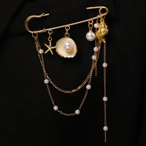 Élégante broche étoile de mer et coquillage doré avec chaînes à pompons multicouches