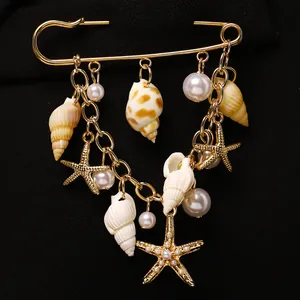 Broche épingle à nourrice dorée avec coquillages, étoile de mer et perles blanches