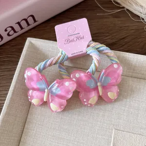 Détail d'élastiques à cheveux papillon en résine rose avec cordons tressés souples