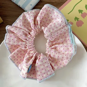 Detalle de coletero de cuadros rosa con puntos rojos y bordes con volantes azules