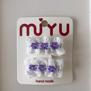 Lot de deux barrettes en dentelle blanche avec broderie de fleurs mauves sur carte