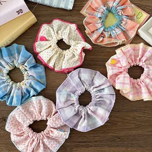 Detalle de coleteros de tela coloridos con motivos de cuadros y lunares con botones decorativos