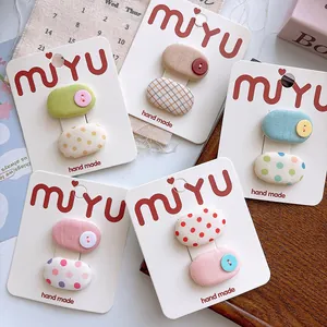 Close-up of sweet polka dot and checkered fabric hair clips on display cards